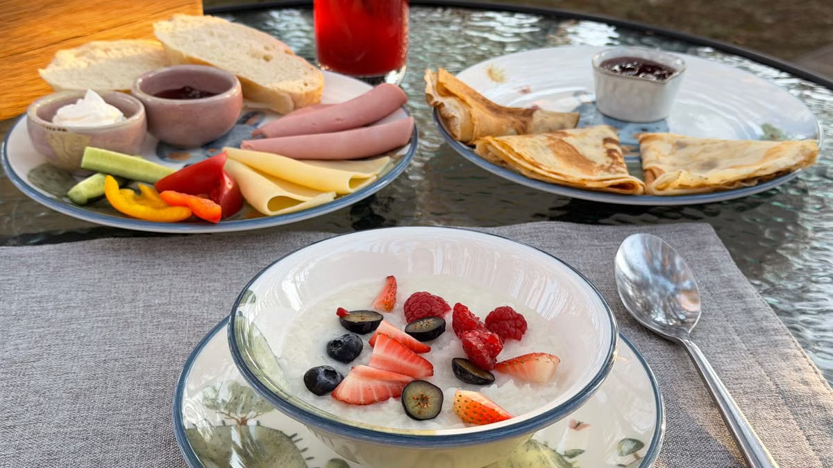 Morning outdoor breakfast with fresh berries, bread, cheese, and crepes.